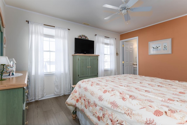 bedroom with ornamental molding, hardwood / wood-style floors, and ceiling fan