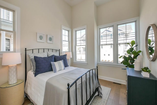 bedroom featuring visible vents, baseboards, and wood finished floors