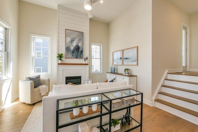 living room featuring stairs, plenty of natural light, and light wood-type flooring