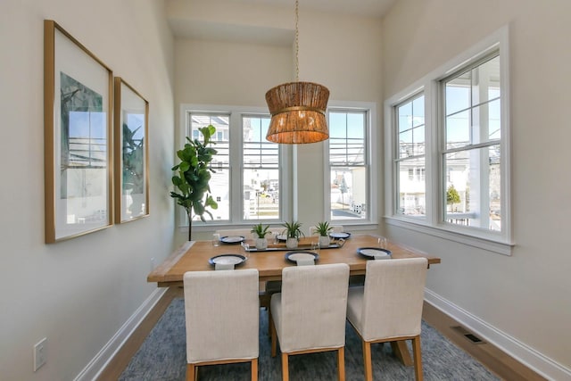 dining space with dark wood-style floors, baseboards, and visible vents