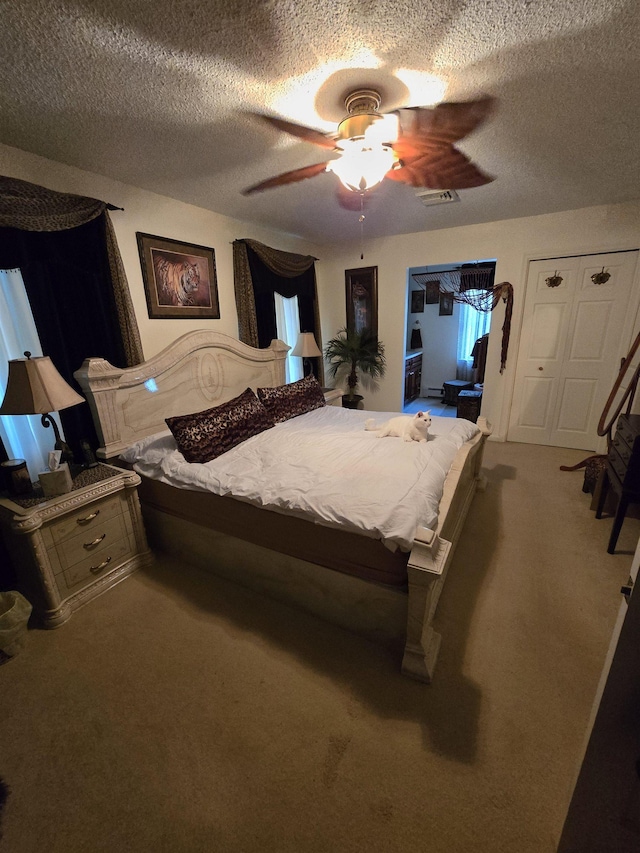 bedroom with carpet flooring, ceiling fan, and a textured ceiling