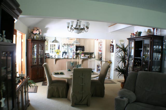 carpeted dining area featuring lofted ceiling and a notable chandelier