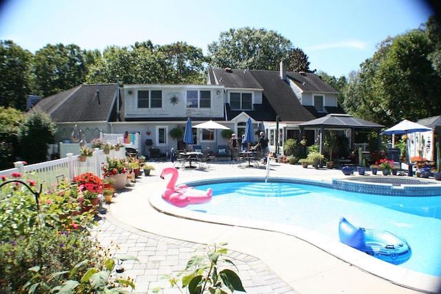 view of swimming pool featuring an in ground hot tub and a patio