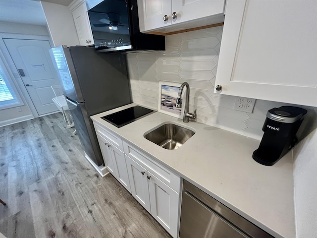 kitchen featuring black appliances, a sink, and white cabinets