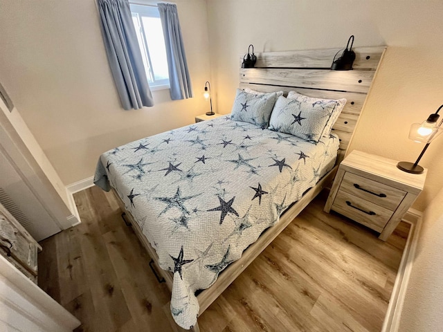 bedroom featuring light wood-style floors and baseboards