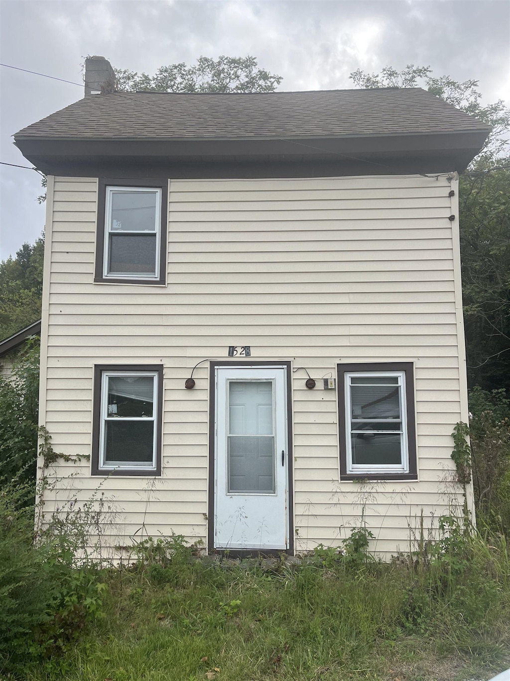 view of front of property with roof with shingles and a chimney
