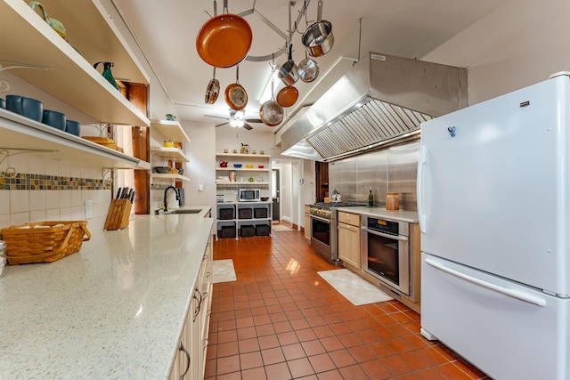 kitchen featuring hanging light fixtures, ceiling fan, light stone countertops, custom range hood, and stainless steel appliances