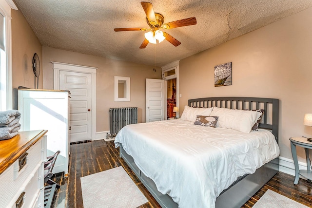 bedroom with radiator heating unit, a textured ceiling, ceiling fan, and dark wood-type flooring