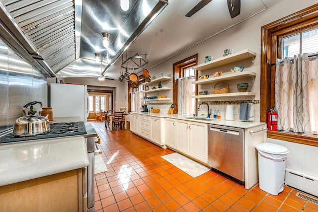 kitchen featuring white cabinets, sink, stainless steel dishwasher, ceiling fan, and light tile patterned floors