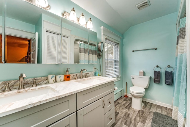 bathroom featuring vanity, a baseboard radiator, toilet, and lofted ceiling