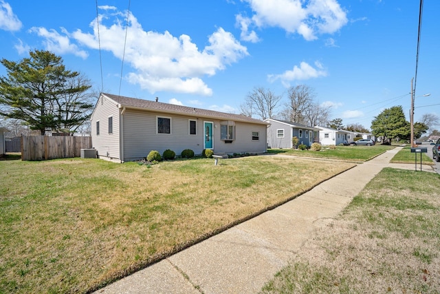 single story home featuring central AC unit, a front lawn, and fence