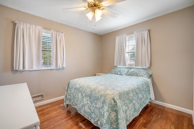 bedroom featuring baseboard heating, baseboards, ceiling fan, and wood finished floors