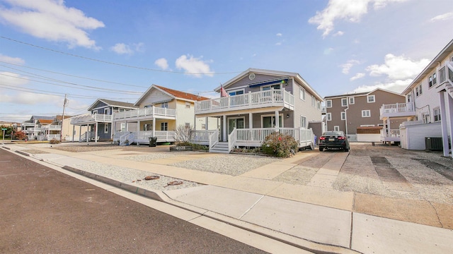 view of front facade featuring cooling unit, covered porch, and a balcony