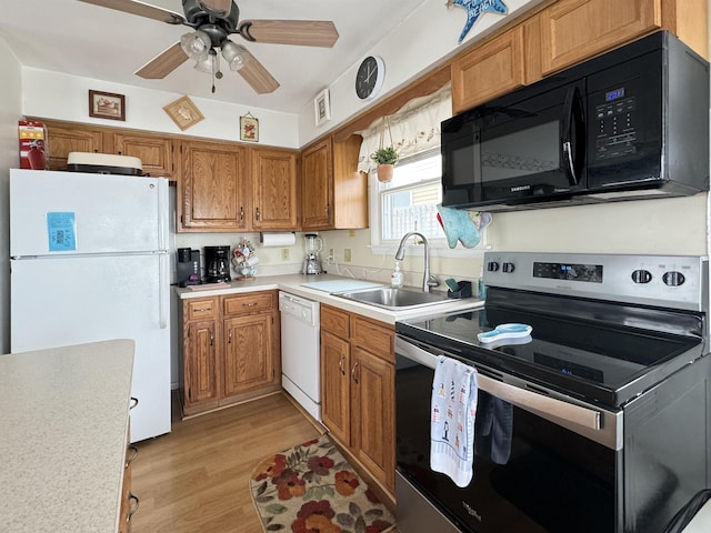 kitchen with ceiling fan, sink, white appliances, and light hardwood / wood-style floors