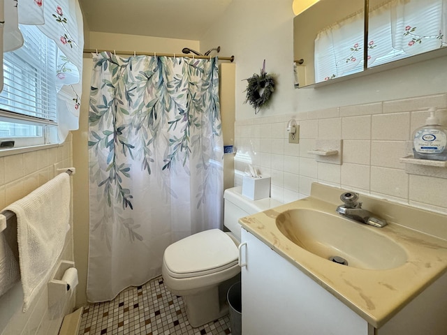 bathroom with tile patterned flooring, vanity, tile walls, and toilet