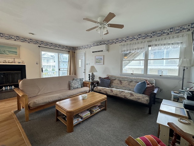 living room featuring hardwood / wood-style flooring, a wall mounted air conditioner, and ceiling fan