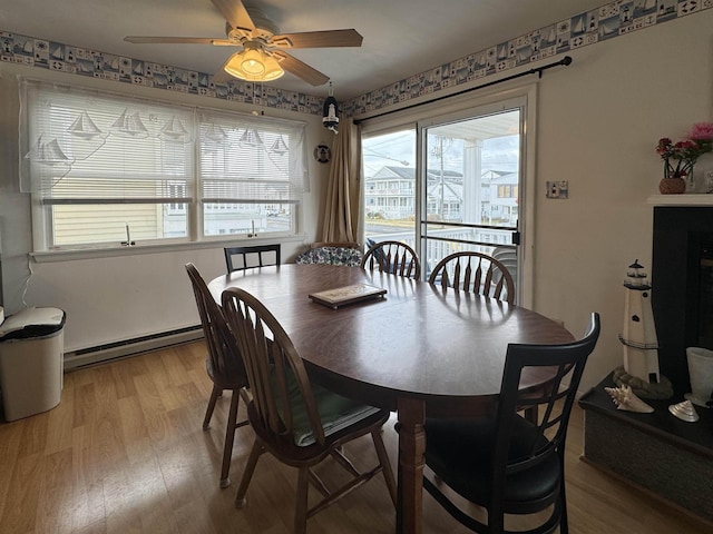 dining room featuring ceiling fan, baseboard heating, and light hardwood / wood-style floors