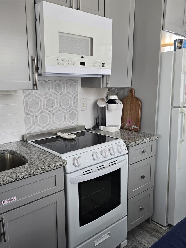 101 E Cresse Ave Unit 1, Wildwood, NJ 08260 - kitchen with white appliances, gray cabinets, decorative backsplash, and light stone counters