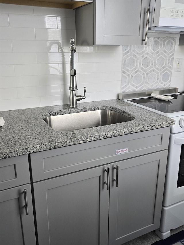 101 E Cresse Ave Unit 1, Wildwood, NJ 08260 - kitchen featuring gray cabinets, white range oven, decorative backsplash, a sink, and light stone countertops