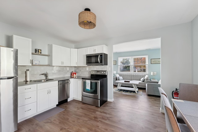 kitchen with dark hardwood / wood-style flooring, white cabinetry, sink, and appliances with stainless steel finishes