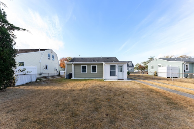 back of property with cooling unit and a lawn