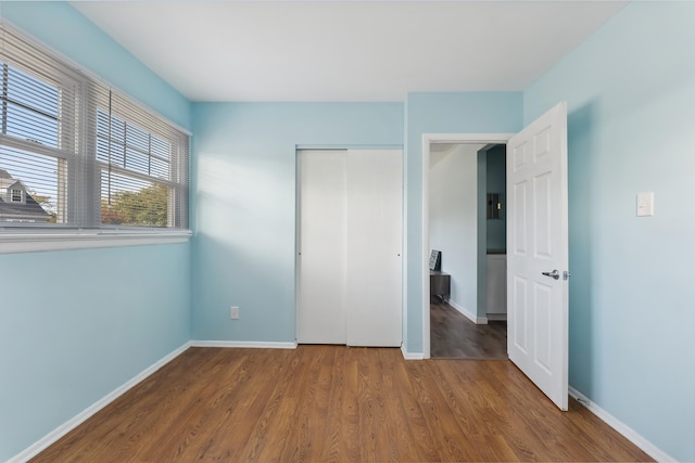 unfurnished bedroom featuring wood-type flooring and a closet