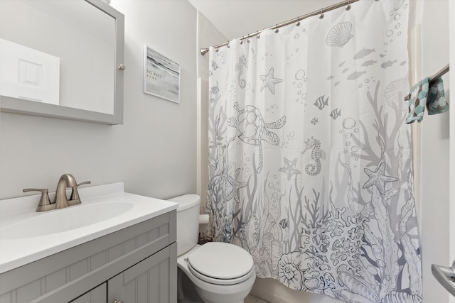 bathroom featuring curtained shower, vanity, and toilet