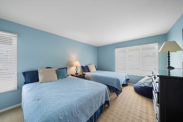 bedroom with light carpet and baseboards