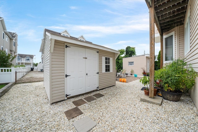 view of shed featuring a gate and fence