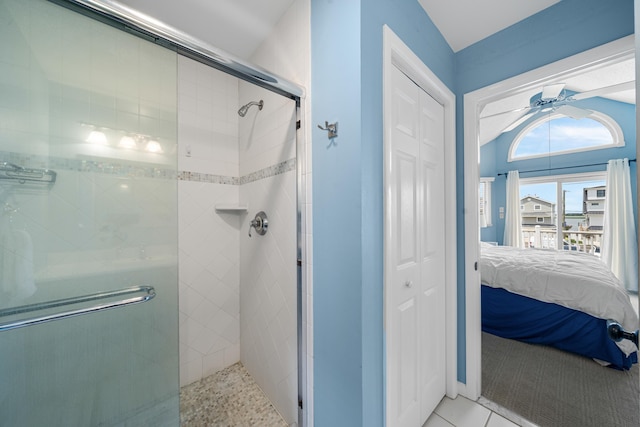 ensuite bathroom featuring tile patterned flooring, a ceiling fan, a closet, a stall shower, and ensuite bath