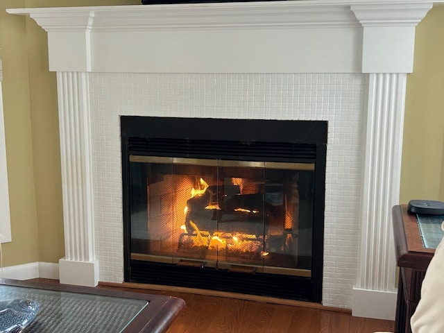 details featuring a fireplace, wood finished floors, and crown molding