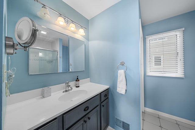 full bath featuring vanity, a shower with door, visible vents, and baseboards