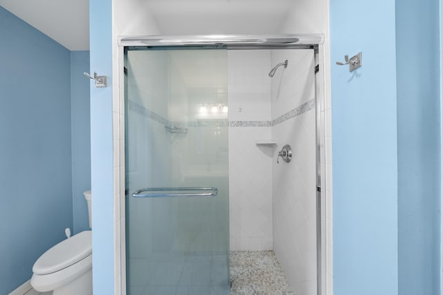 bathroom featuring a stall shower and toilet