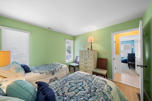 bedroom featuring carpet, tile patterned flooring, and visible vents