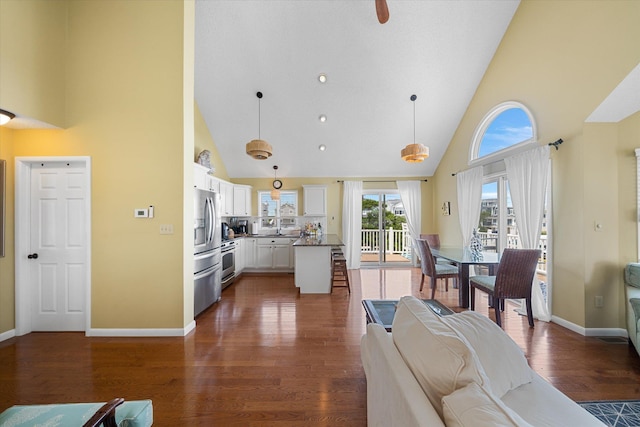 living room with baseboards, high vaulted ceiling, and dark wood-style flooring