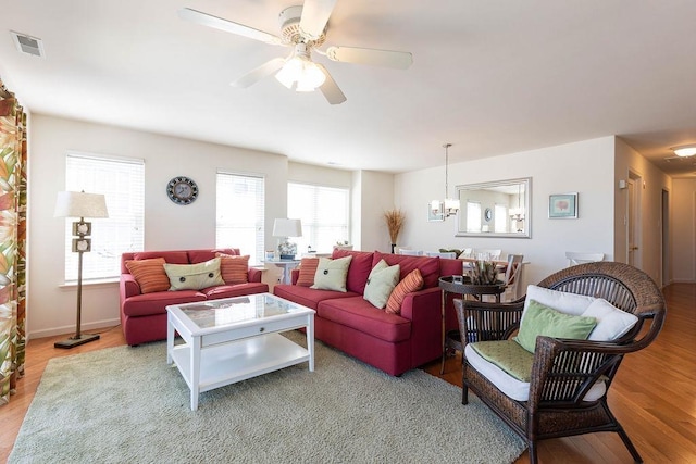 living room featuring hardwood / wood-style floors and ceiling fan with notable chandelier