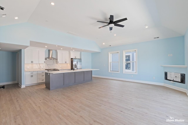 403 E Glenwood Ave Unit 15, Wildwood, NJ 08260 - kitchen featuring wall chimney range hood, lofted ceiling, stainless steel refrigerator with ice dispenser, an island with sink, and light wood finished floors