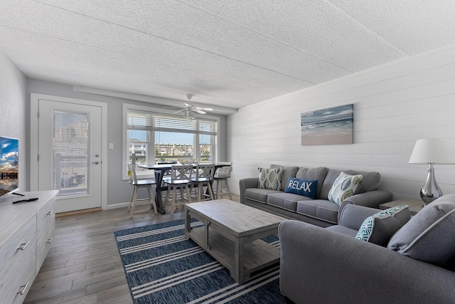 9103 Atlantic Ave Unit 407, Wildwood Crest, NJ 08260 - living room featuring dark wood finished floors, a textured ceiling, wood walls, and ceiling fan