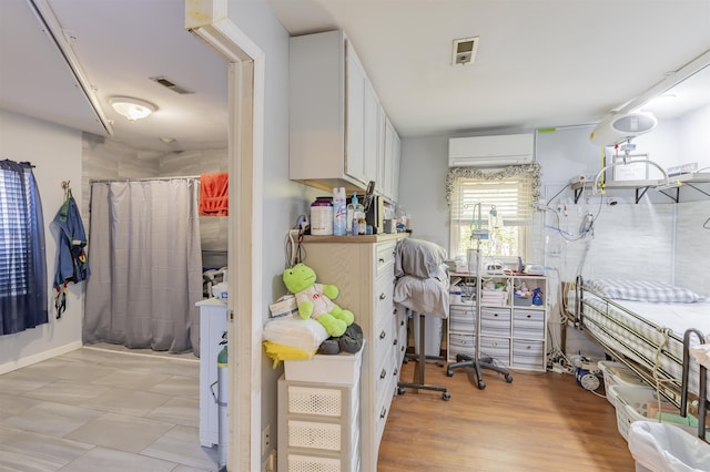 home office with an AC wall unit and visible vents