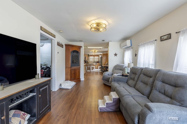 living area featuring dark wood-style flooring and a wall mounted AC