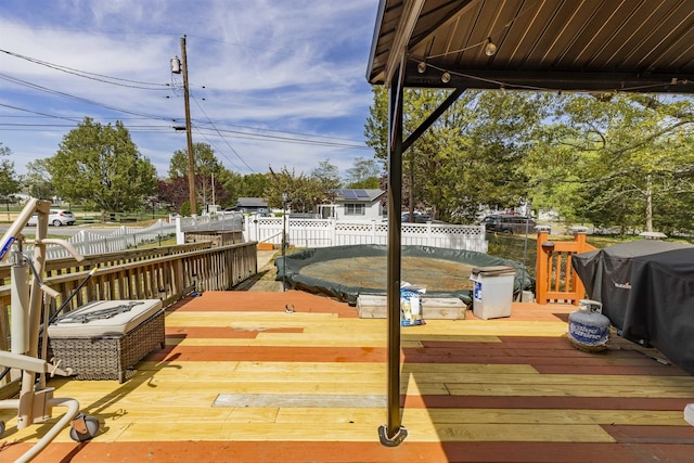 wooden terrace with a fenced backyard
