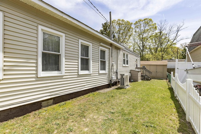view of yard with ac unit, a shed, a fenced backyard, central air condition unit, and an outdoor structure