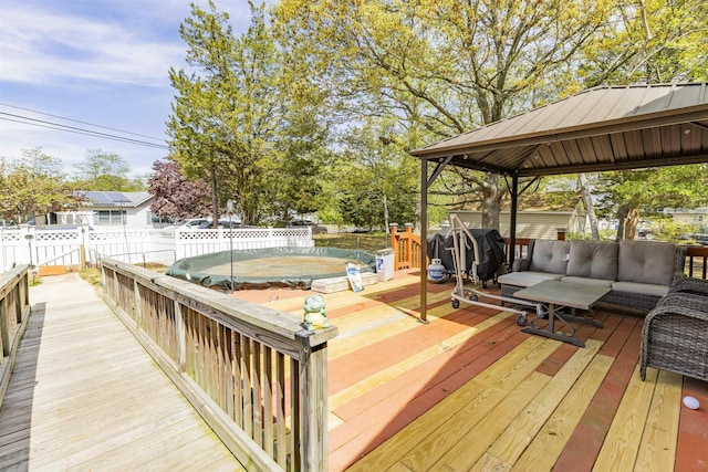 deck with fence, a gazebo, and an outdoor hangout area