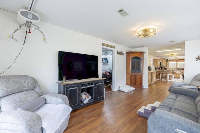 living room with dark wood-style floors and visible vents