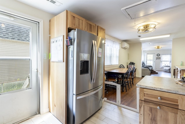 kitchen featuring visible vents, a wall mounted air conditioner, open floor plan, light countertops, and stainless steel fridge with ice dispenser