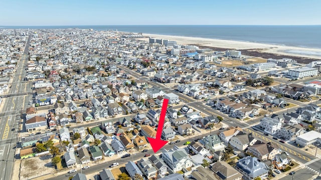 birds eye view of property featuring a water view, a residential view, and a beach view