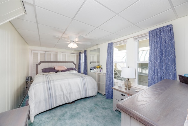 bedroom featuring a ceiling fan, a paneled ceiling, and light colored carpet