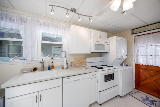 kitchen with white appliances, white cabinetry, light countertops, and a sink