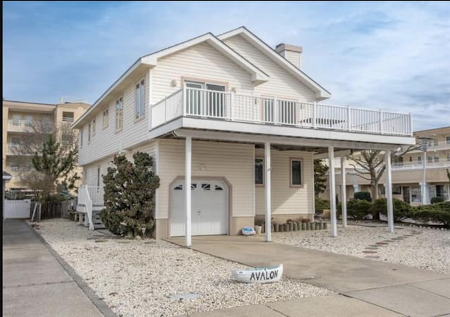 141 8th St, Avalon, NJ 08202 - view of front facade featuring an attached garage, a chimney, and driveway