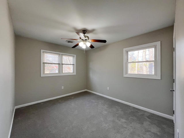 unfurnished room with dark carpet and ceiling fan